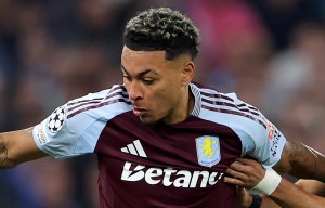 Aston Villa's Morgan Rogers challenged by a Bayern Munich player during a soccer match.