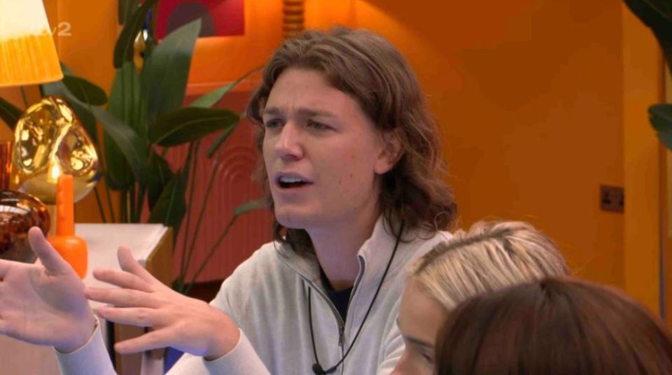 a man with long hair is talking to a group of people