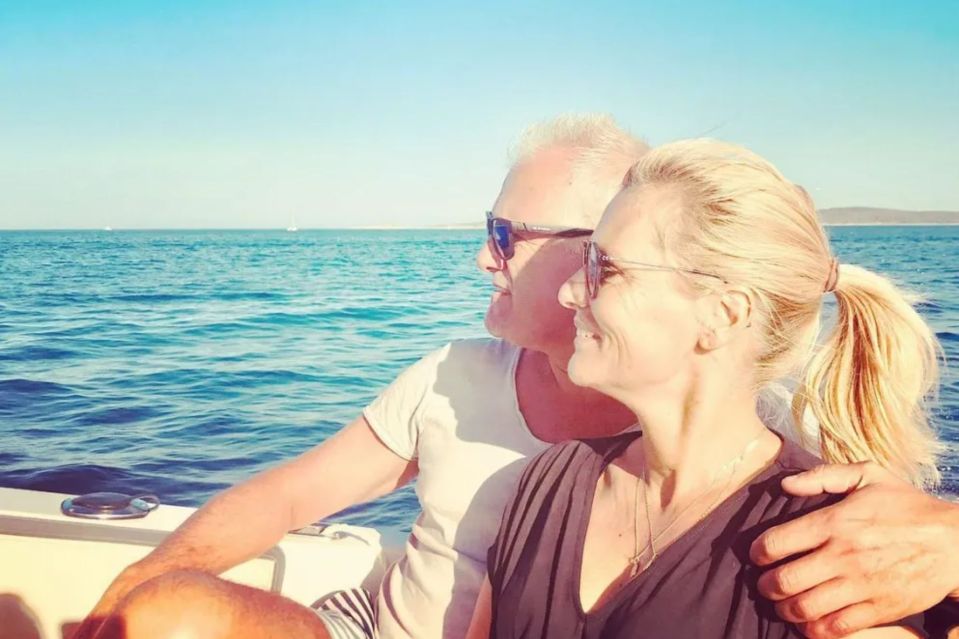 a man and a woman are sitting on a boat in the ocean