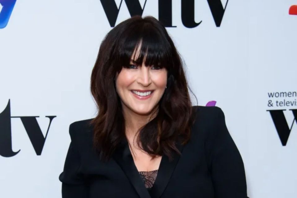 a woman smiles in front of a sign that says women and television