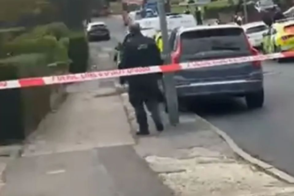a man is walking down a sidewalk next to a police tape .