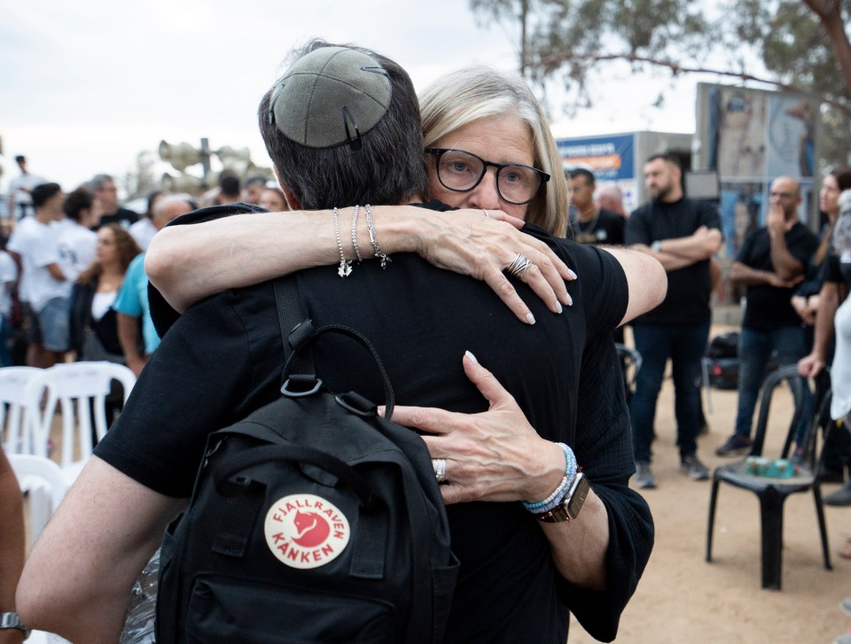 a woman hugging a man wearing a black kanken backpack
