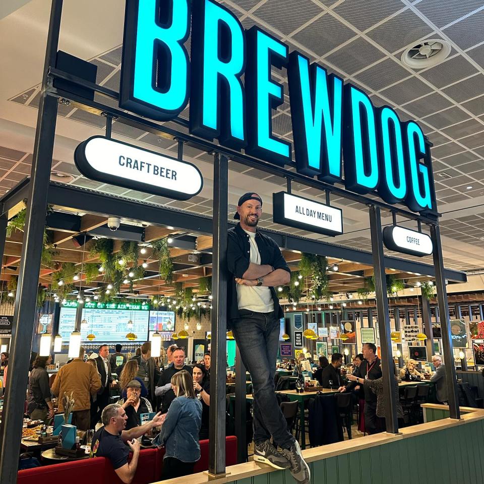 a man stands in front of a brewdog restaurant