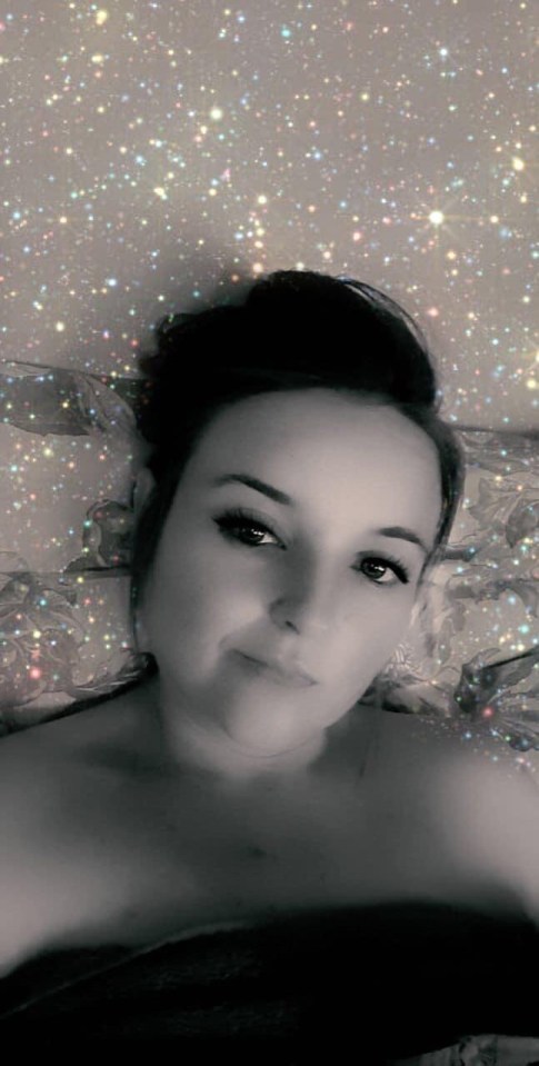 a woman is laying on a bed in a black and white photo .