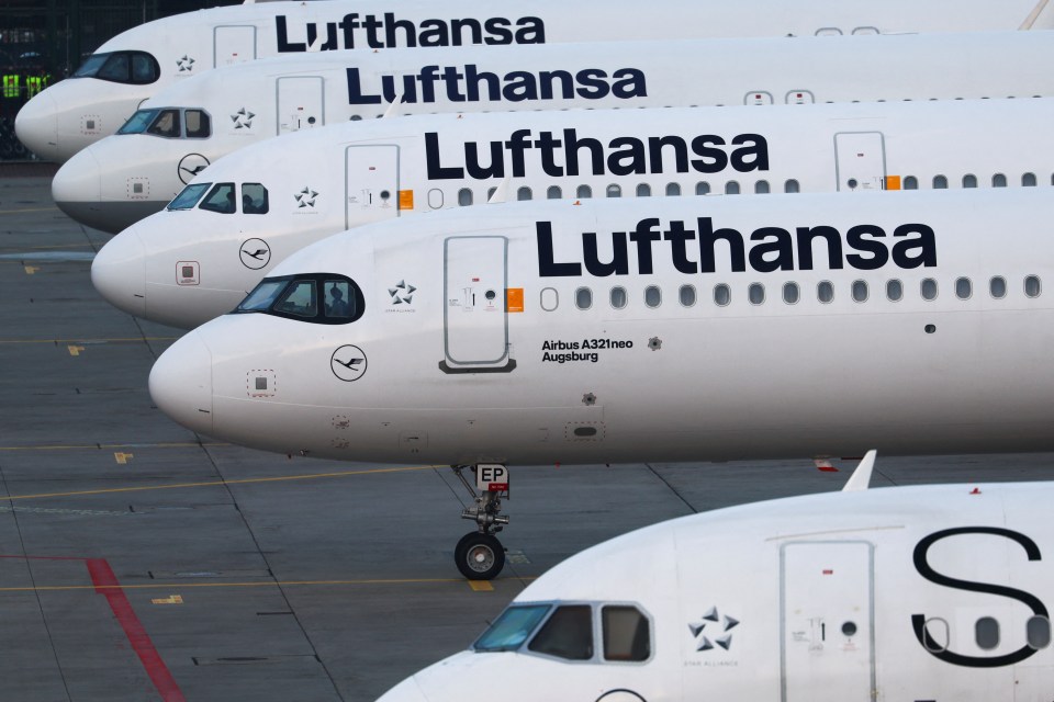 a row of lufthansa airplanes are parked on the tarmac