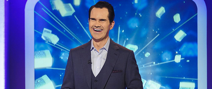 a man in a suit and tie is smiling in front of a blue background