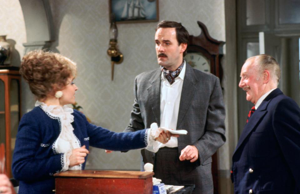 a man in a suit shakes hands with a woman in a blue jacket