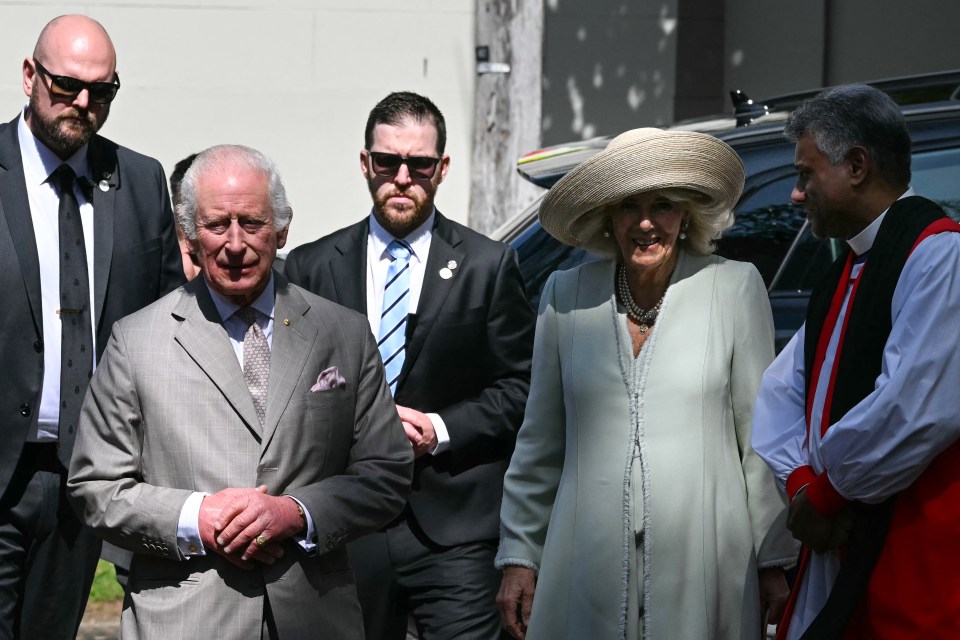 a man in a suit and tie stands next to a woman in a hat