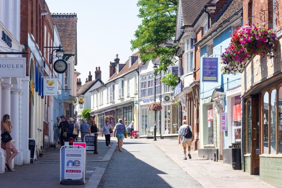 people walking down a narrow street with a sign that says indian cuisine