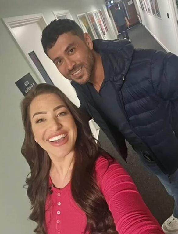 a man and a woman pose for a selfie in front of a door that says 20