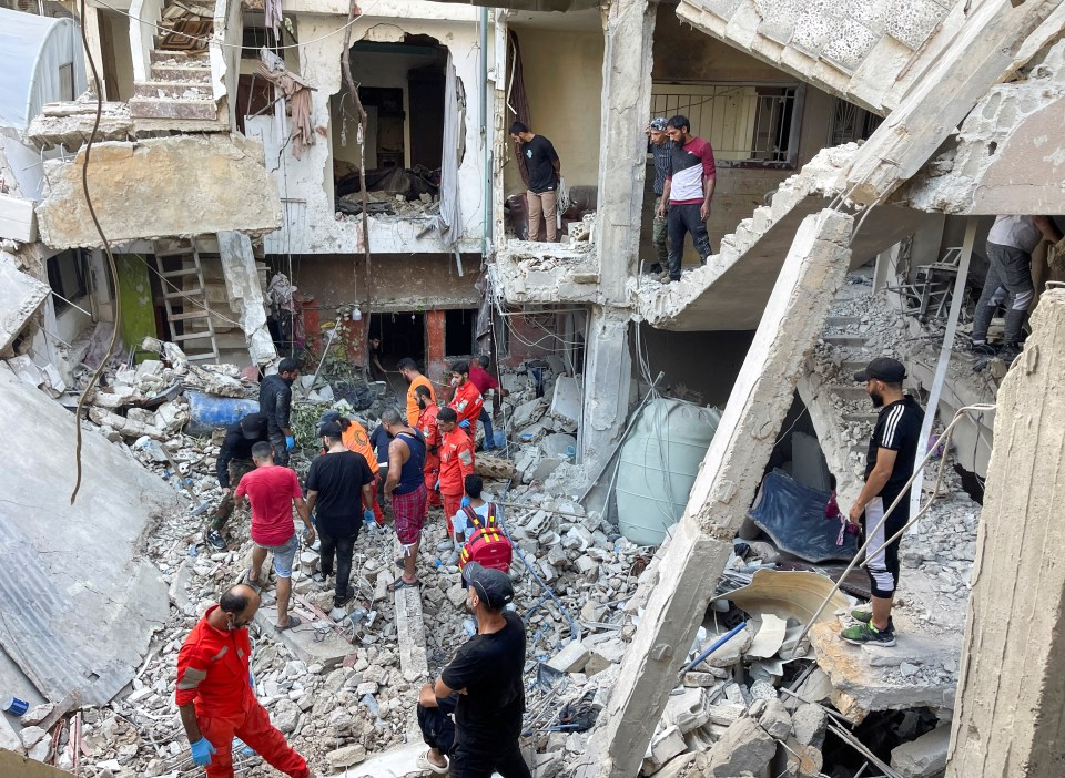 a group of people are standing in the rubble of a building