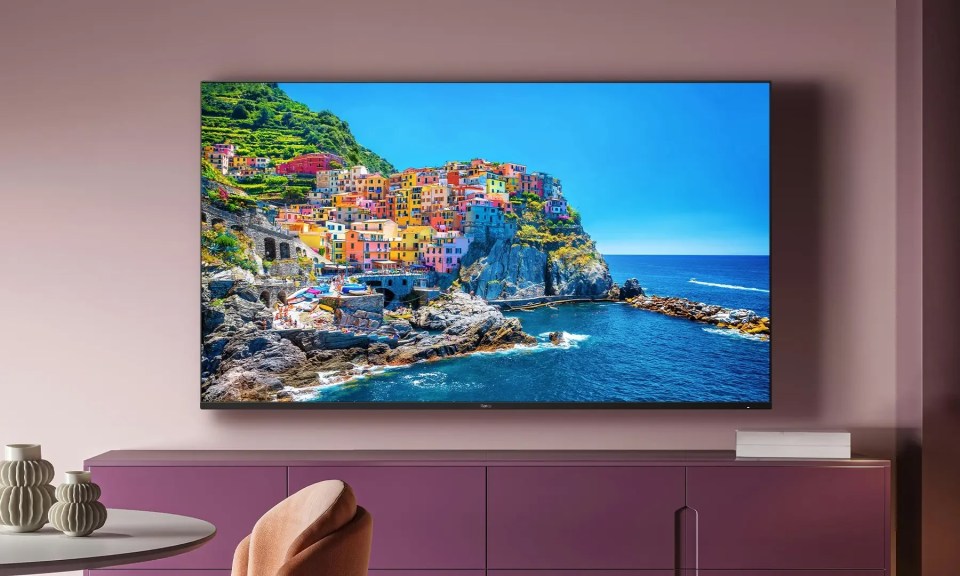 a tv displays a picture of a cliff overlooking the ocean