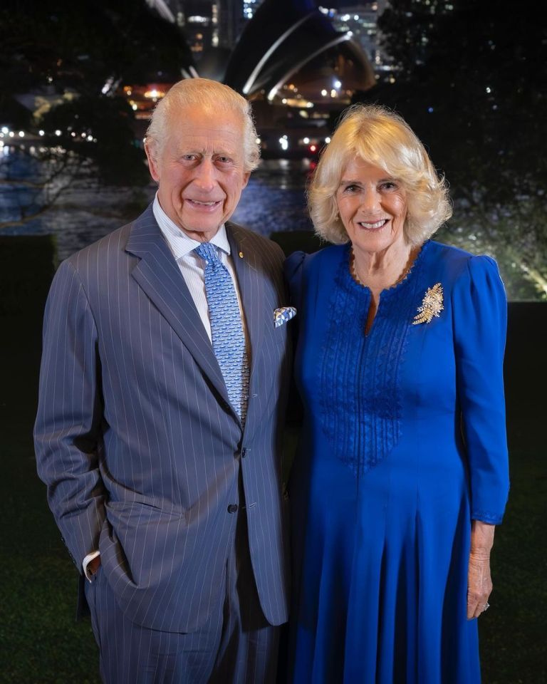 a man in a suit and tie stands next to a woman in a blue dress