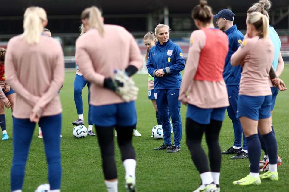 a group of soccer players are gathered on a field and one has the number 8 on her jacket