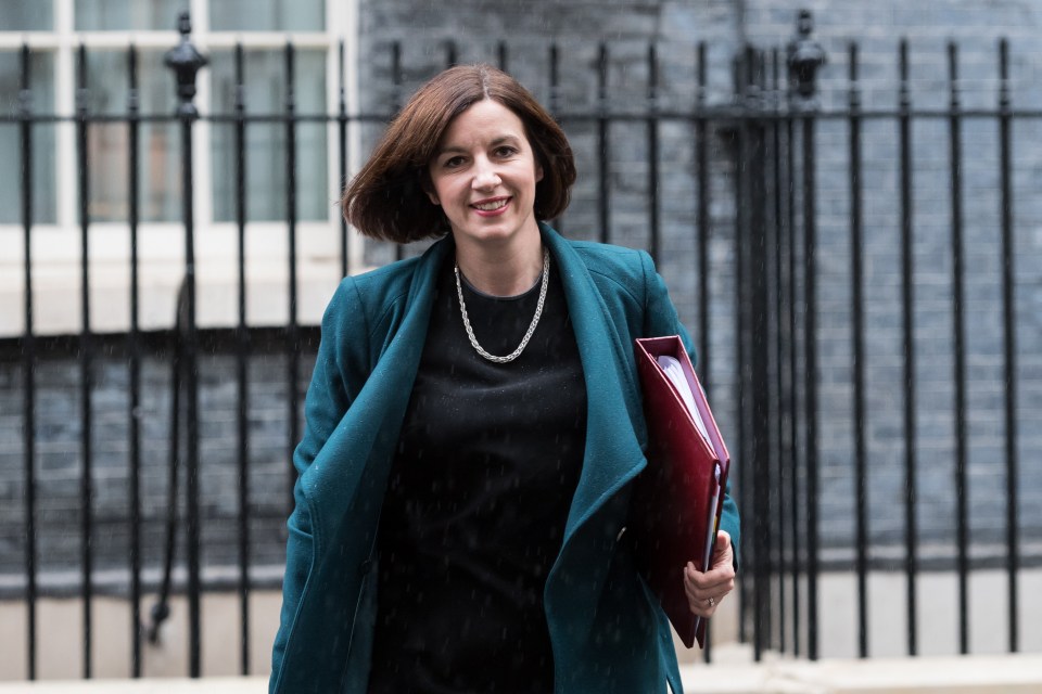 a woman in a blue coat is holding a red folder