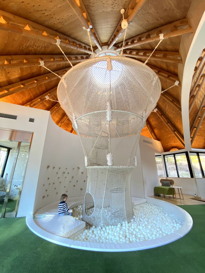 a child is playing in a ball pit under a dome