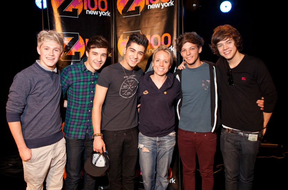 a group of young men pose with a woman in front of a sign that says 100 new york