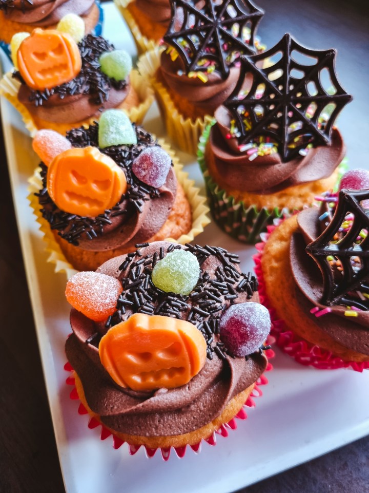 a white plate topped with cupcakes decorated for halloween
