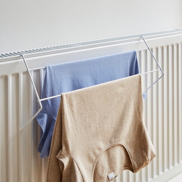 two shirts are hanging on a rack on a radiator