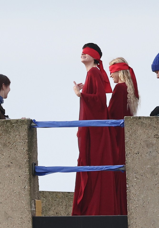 two women wearing red blindfolds are standing next to each other