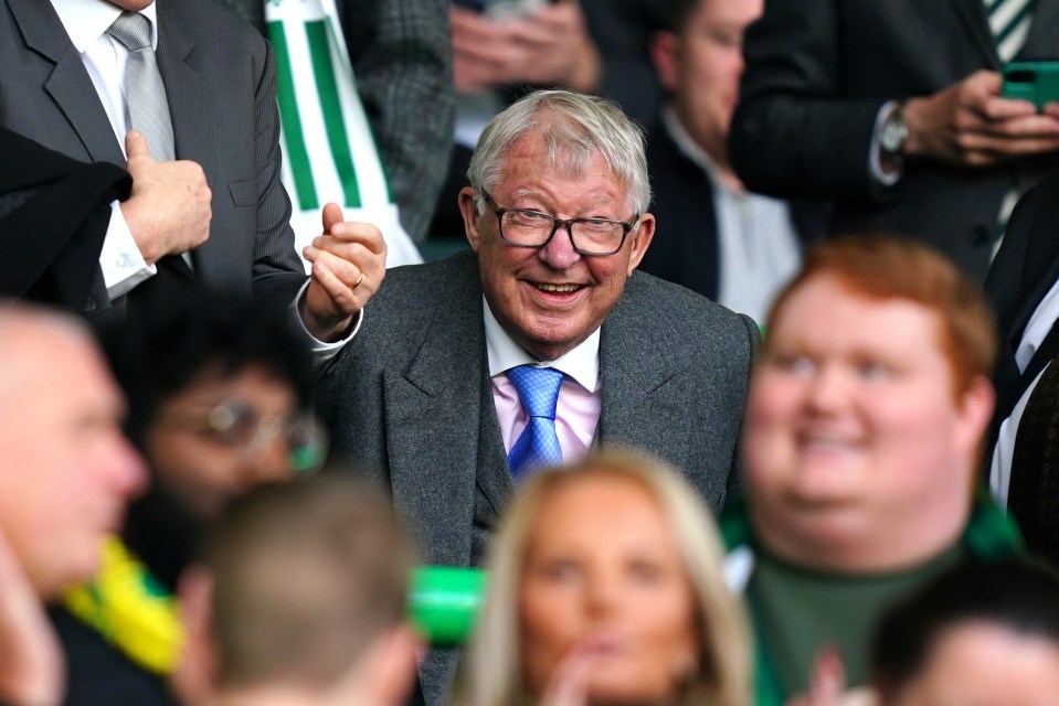 a man in a suit and tie is laughing in a crowd