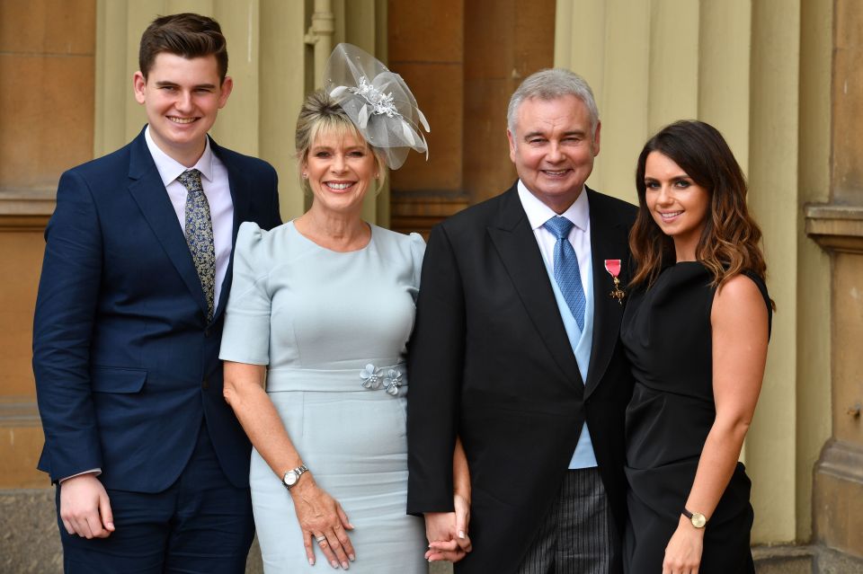 a family posing for a picture with a man in a suit and tie