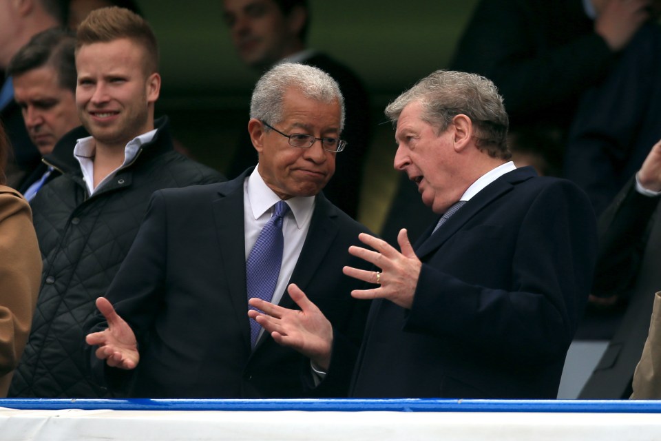 two men in suits and ties are talking to each other