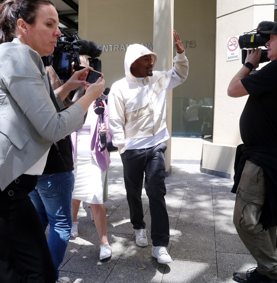 a man in a white hoodie is being interviewed by a group of people