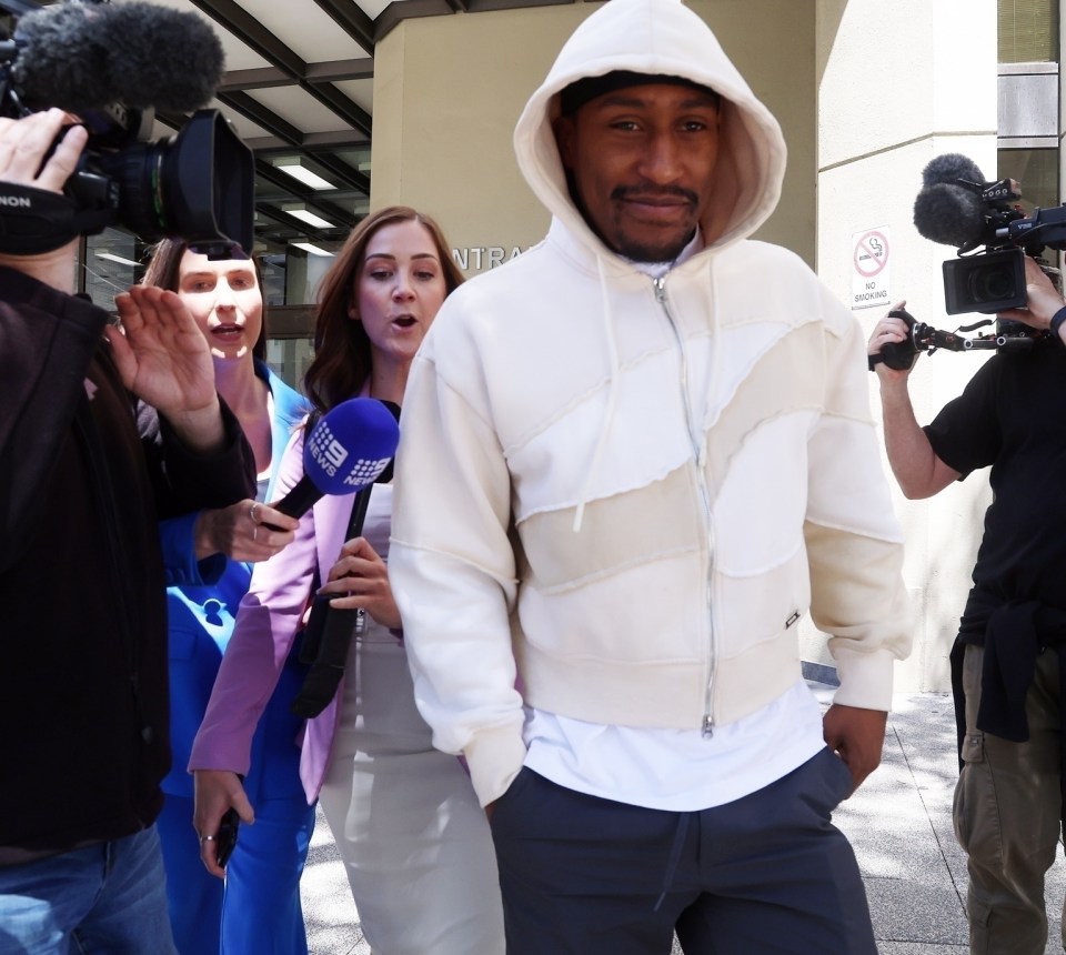 a man wearing a white hoodie is surrounded by a group of people