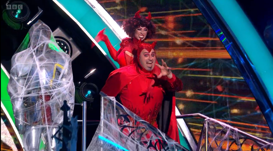 a man and a woman in devil costumes on a stage