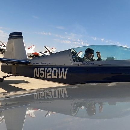 a man is sitting in the cockpit of a small plane .