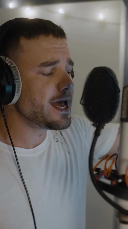 a man wearing headphones is singing into a microphone