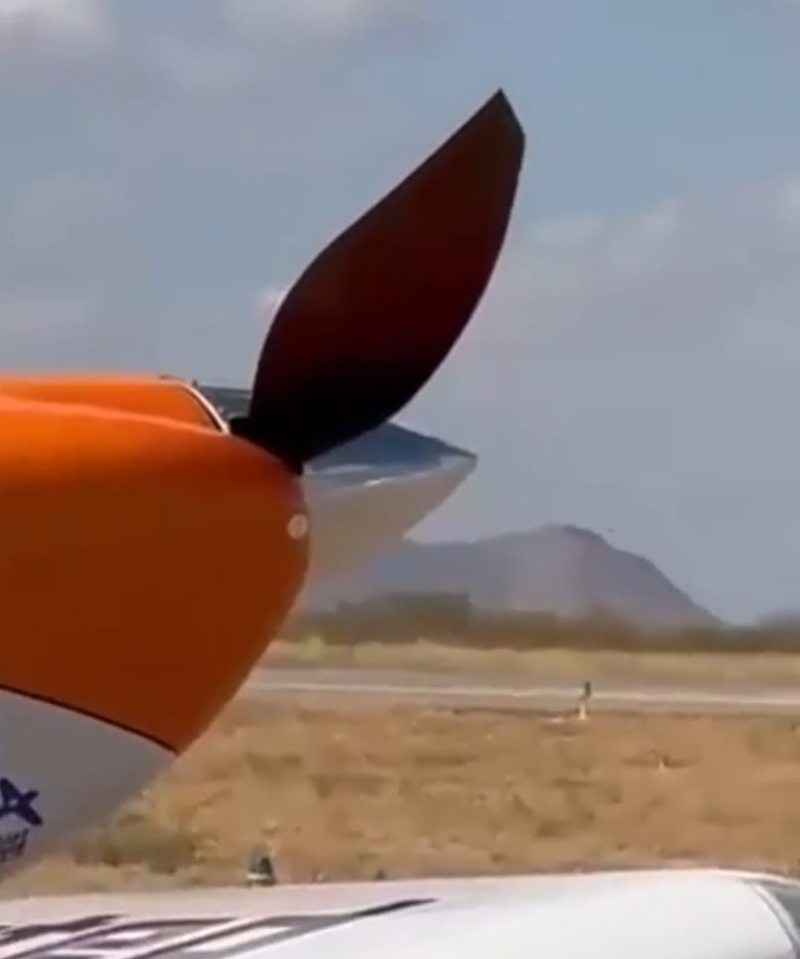a close up of an airplane propeller with mountains in the background
