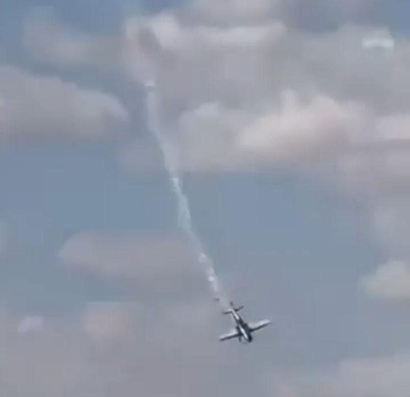 a plane is flying through a cloudy sky with smoke coming out of it .