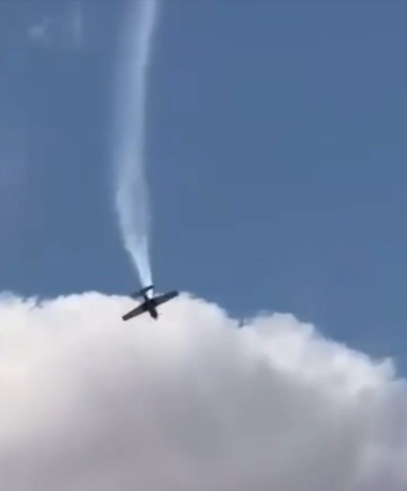 a small plane is flying through a cloudy blue sky .