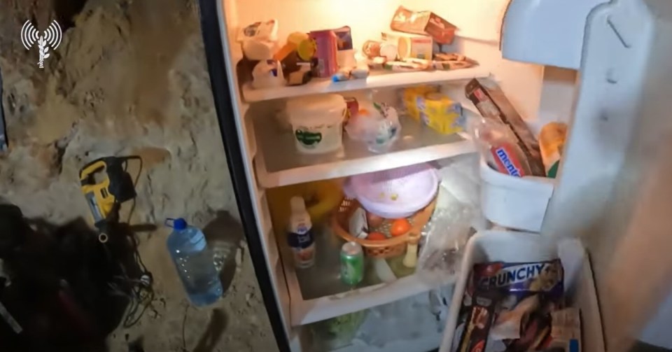 the inside of a refrigerator with a bag of crunchy candy on the bottom shelf