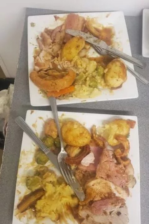 two plates of food with knives and forks on a table .
