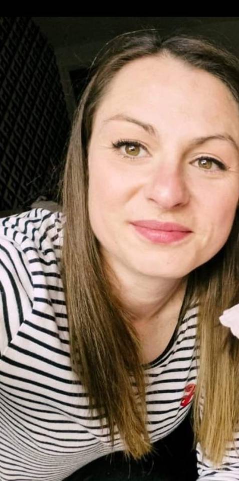 a woman in a striped shirt is taking a selfie .