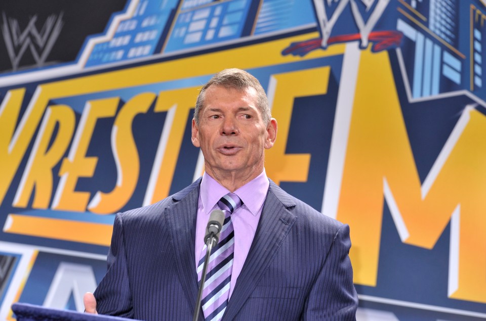 a man in a suit stands in front of a sign that says wrestle fm