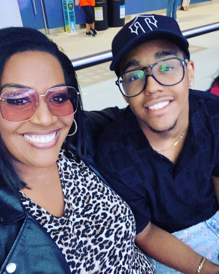 a man wearing a ny hat sits next to a woman wearing sunglasses
