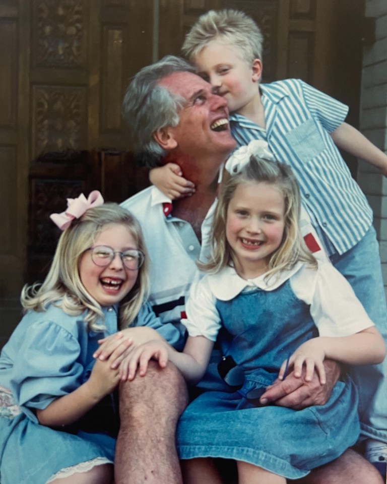 a man and three children are posing for a picture