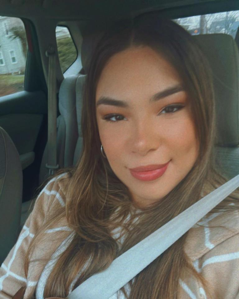 a woman is smiling while sitting in the back seat of a car
