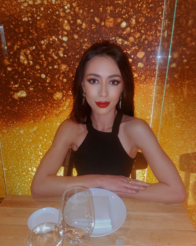 a woman in a black top sits at a table