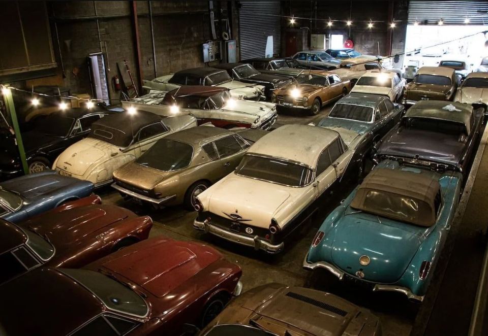 a bunch of old cars are lined up in a garage