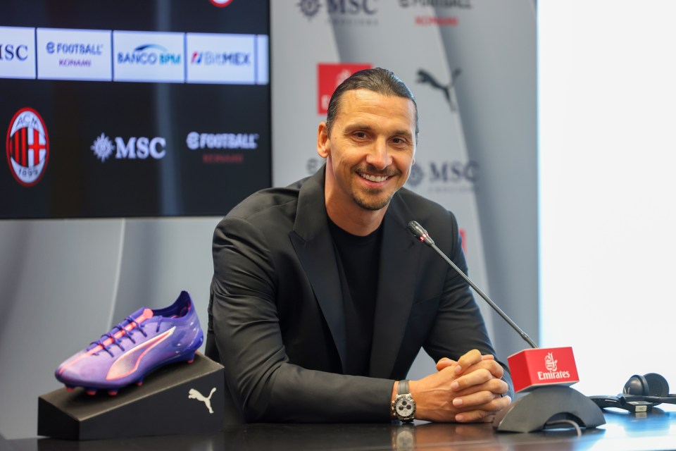 a man sitting in front of a microphone with a sign that says emirates on it