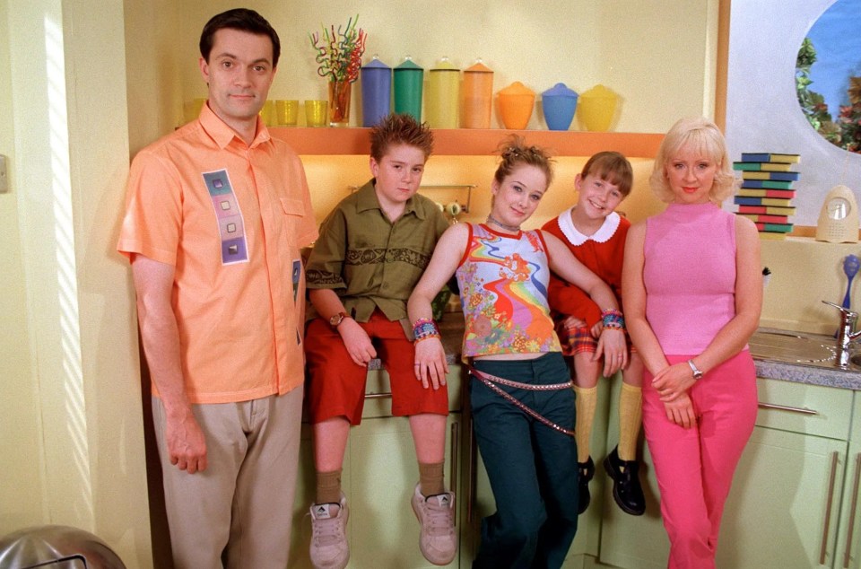 a group of people posing for a picture in a kitchen