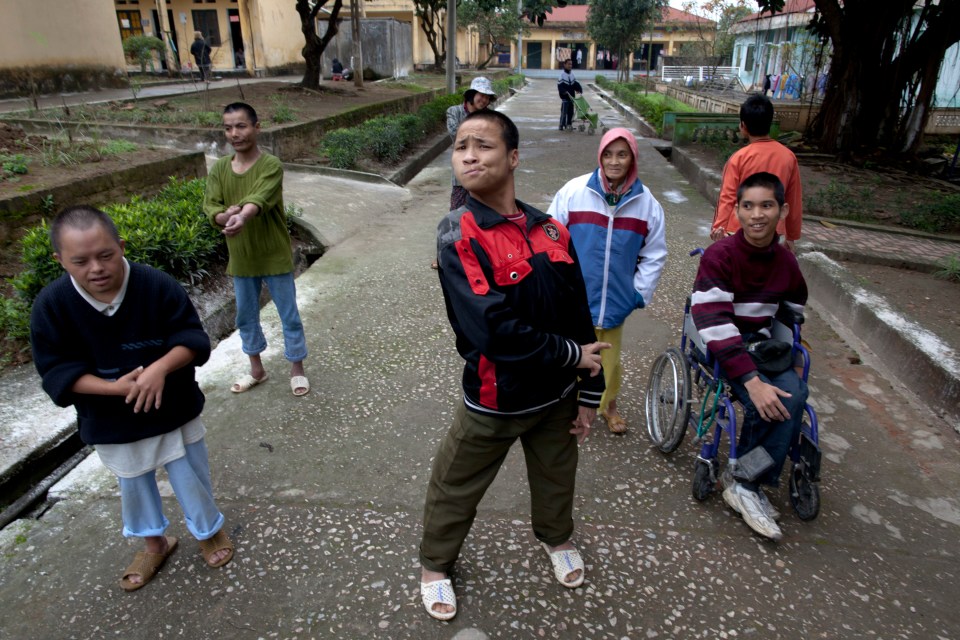 a group of people standing on a sidewalk with one wearing a jacket that says nike