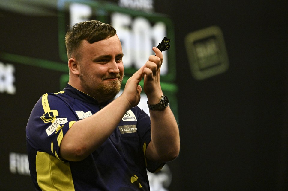 a man in a blue and yellow shirt holds up a dart