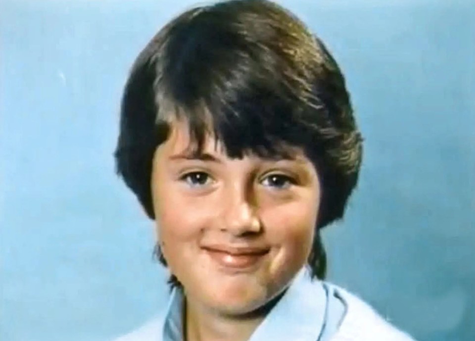 a young boy with short hair is smiling for the camera .