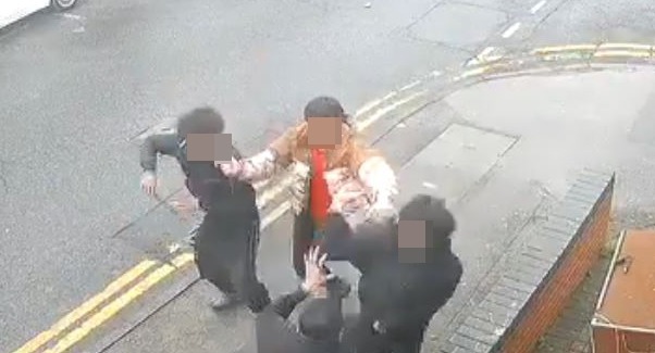 a group of people are standing on the side of a street .
